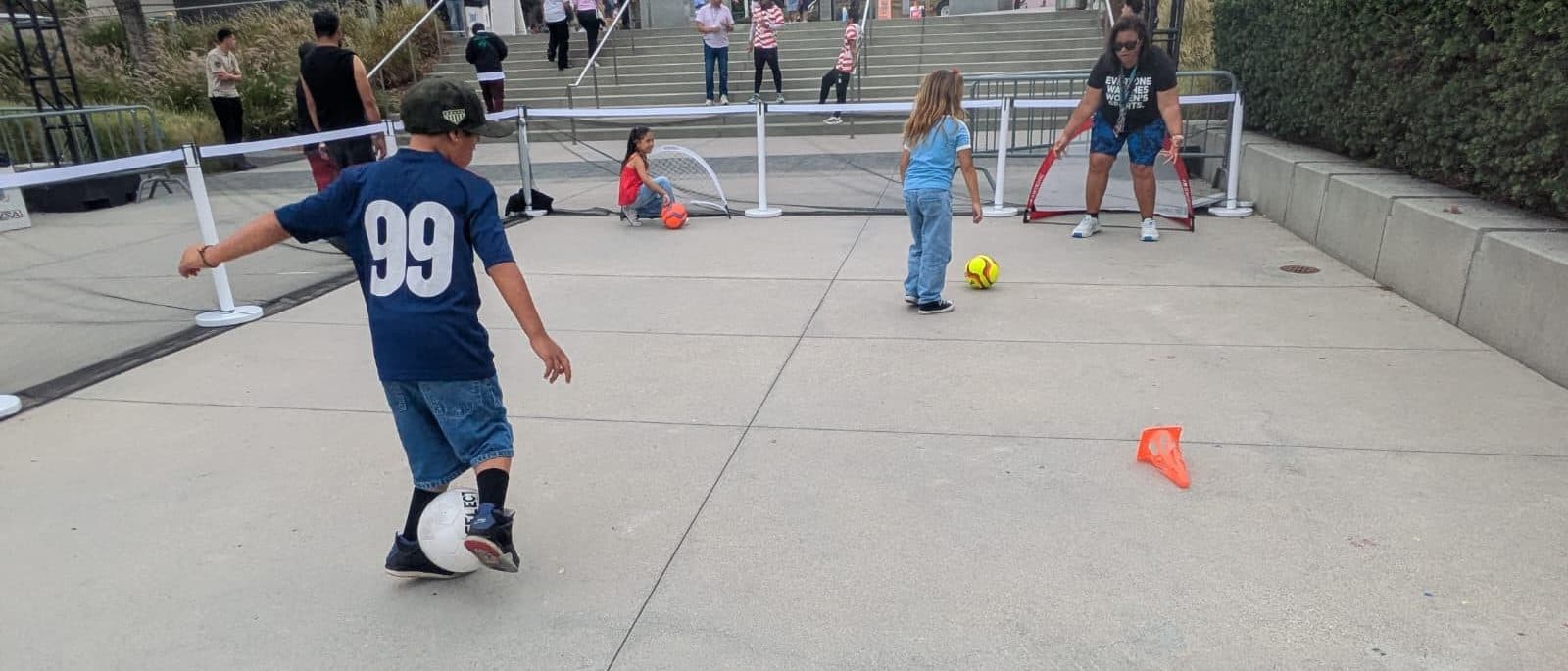 Kids playing football at a free SFG community event in a city park